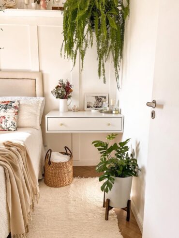 Quarto com plantas e penteadeira branca suspensa