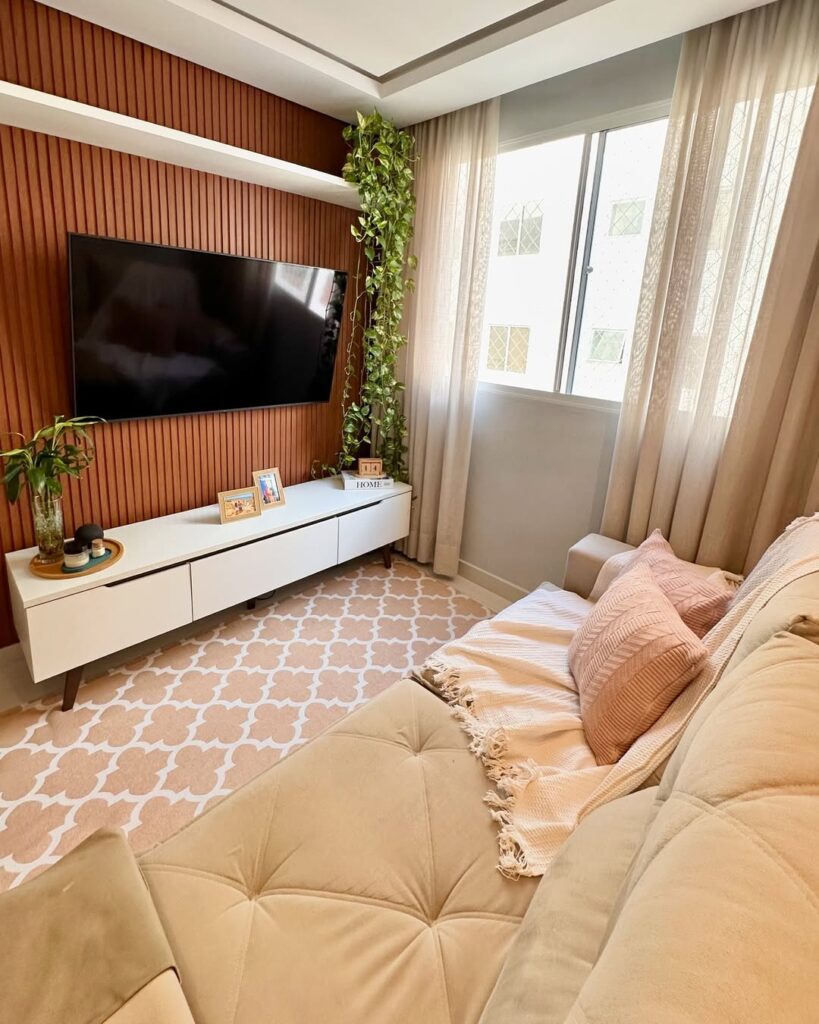 Sala com sofá claro, painel ripado para a tv e prateleira branca