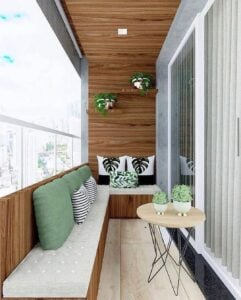 Varanda com sofá, almofadas, plantas e mesinha