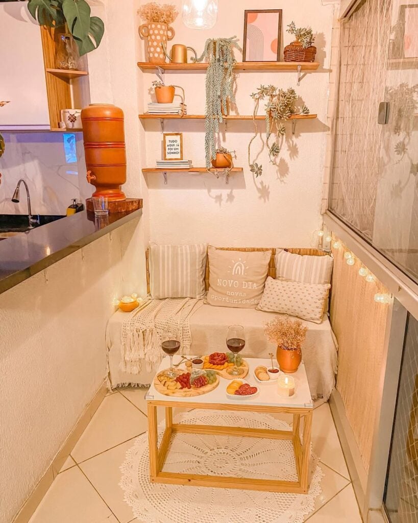 Varanda de apartamento com sofá, almofadas e prateleiras com enfeites