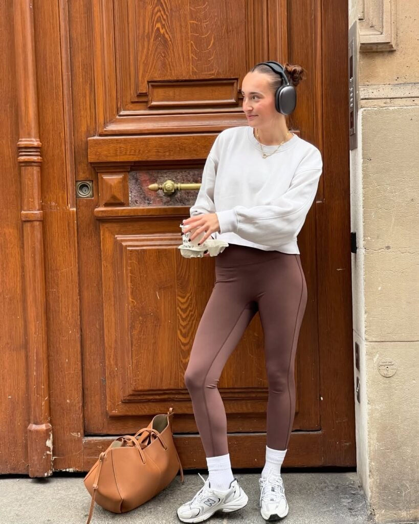 Mulher jovem com moletom, calça legging, tênis e meia branca