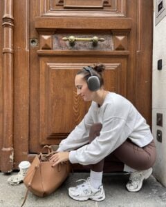 Mulher jovem com moletom, calça legging, tênis e meia branca