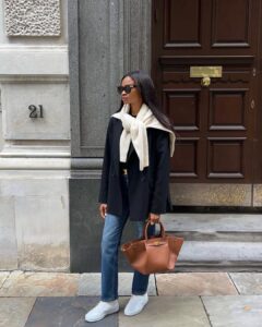 mulher jovem com blazer, calça jeans e tênis