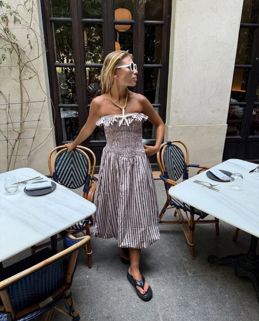 Mulher jovem com vestido sem alça de estampa listrada