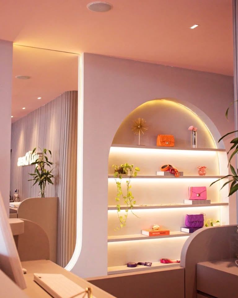 Ambiente com arco embutido no revestimento com prateleiras, iluminação e bolsas