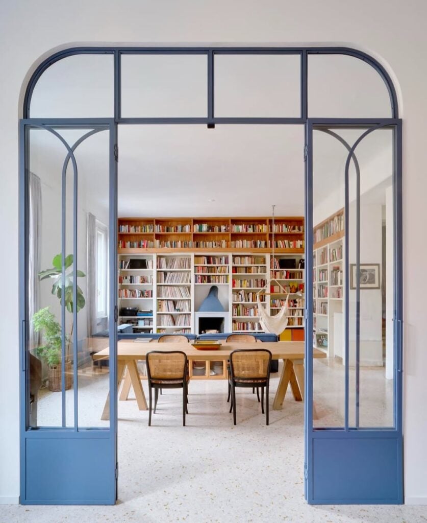 Arco azul de frente para uma estante com livros