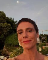Atriz Malu Galli com batom alaranjado e brinco branco