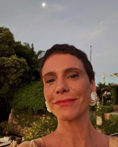 Atriz Malu Galli com batom alaranjado e brinco branco