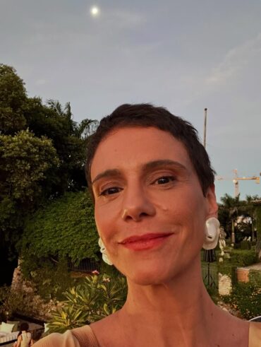 Atriz Malu Galli com batom alaranjado e brinco branco