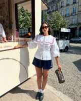 mulher com blusa feminina com babador, bermuda e mocasim com meia
