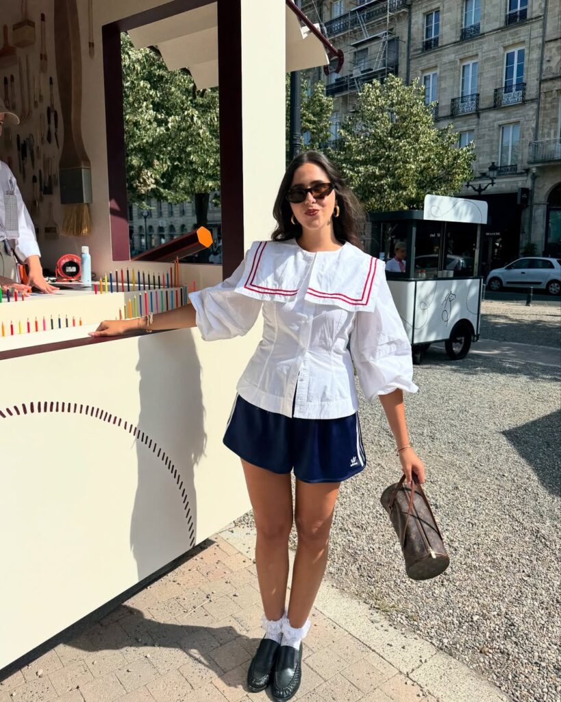 mulher com blusa feminina com babador, bermuda e mocasim com meia
