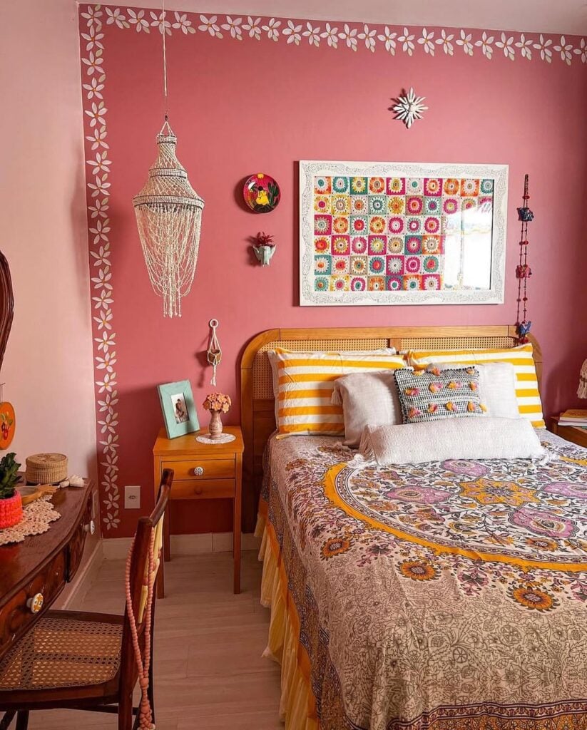 Quarto com paredes rosa, cabeceira de telinha e quadro colorido