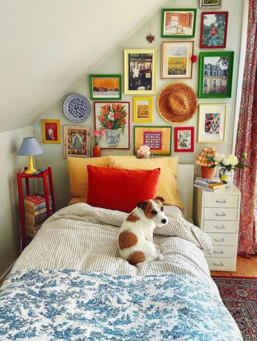 Quarto com cama de solteiro, quadrinhos e outros objetos coloridos acima da cama