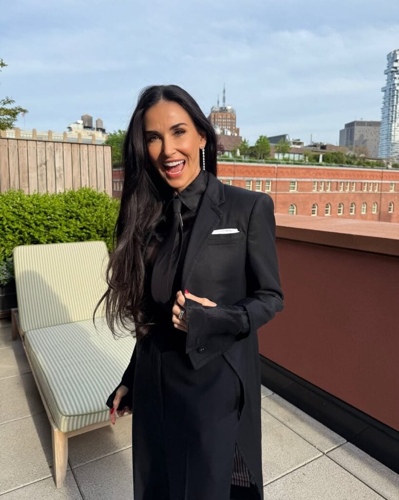 Demi Moore com roupa preta e cabelo extralongo