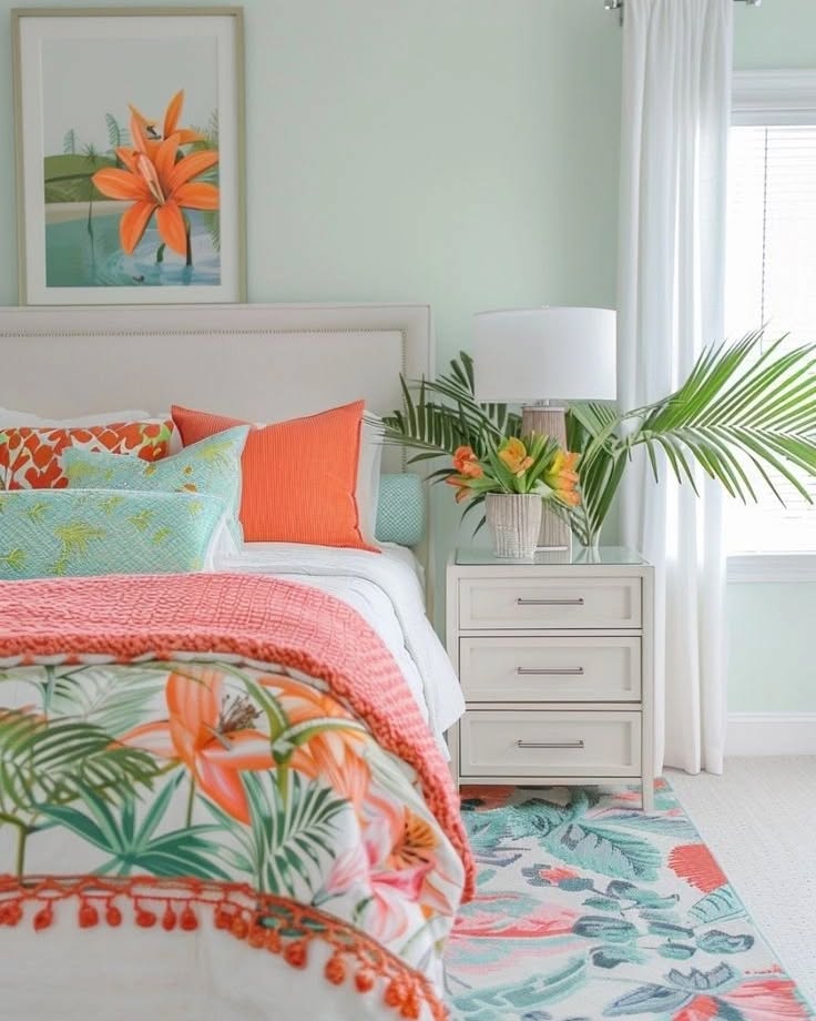 Quarto com móveis brancos e roupa de cama em laranja e verde com flores