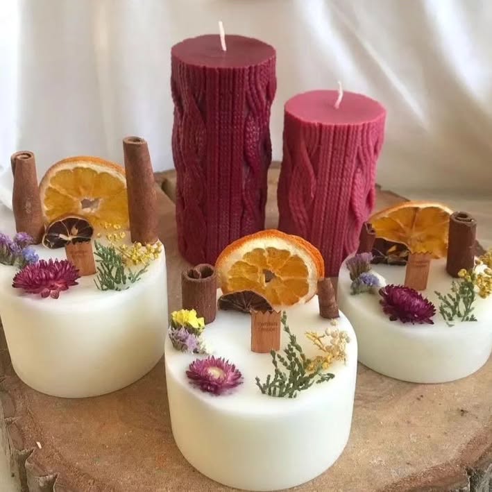 Velas aromáticas decoradas com flores e rodelas de laranja seca