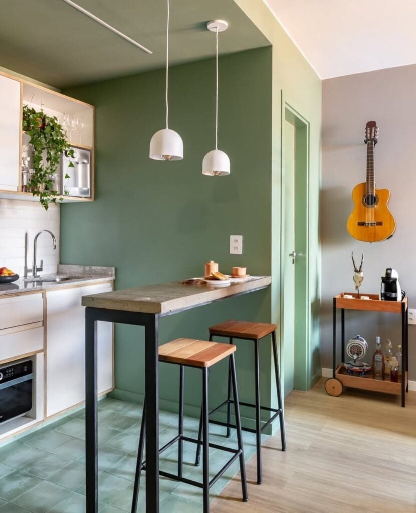 Cozinha com península e parede verde