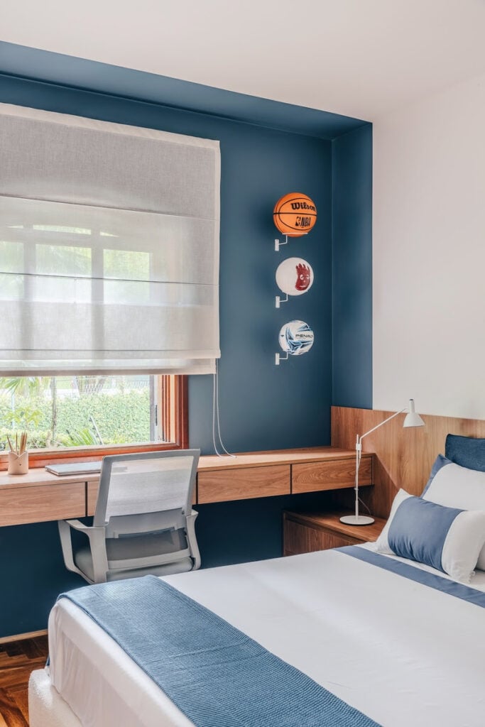 Quarto com bancada de madeira e parede azul