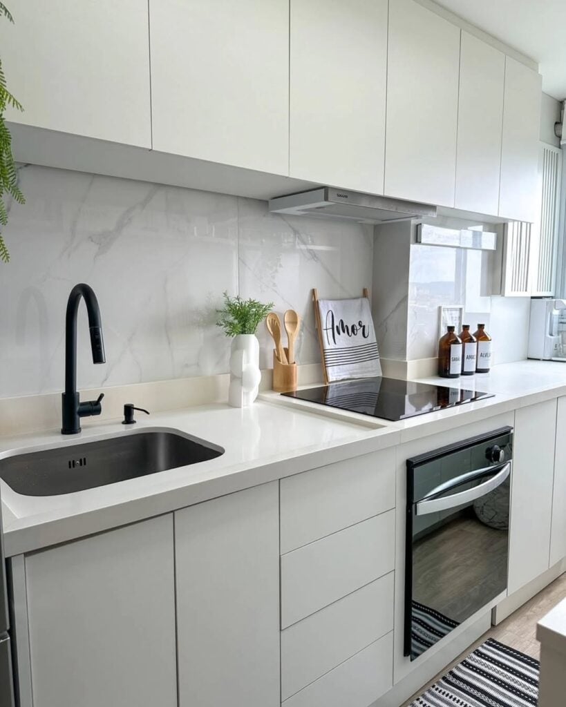 Cozinha com armários e revestimento em cores claras