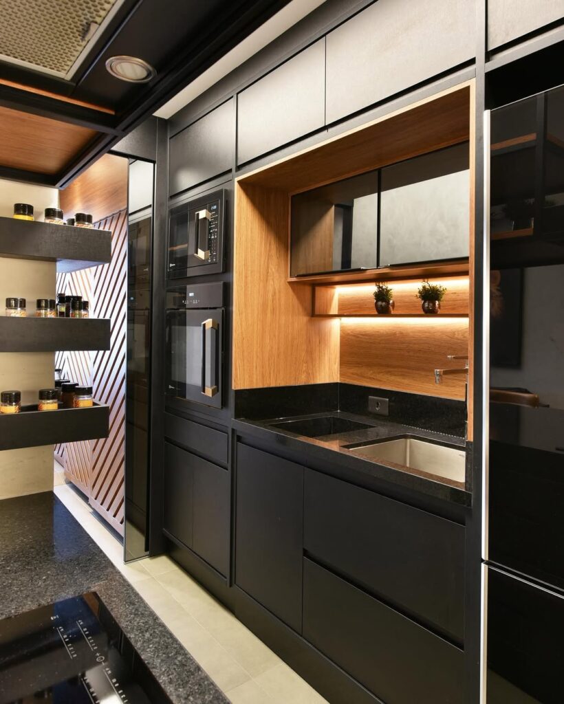Cozinha com armários e pia pretos e detalhes amadeirados