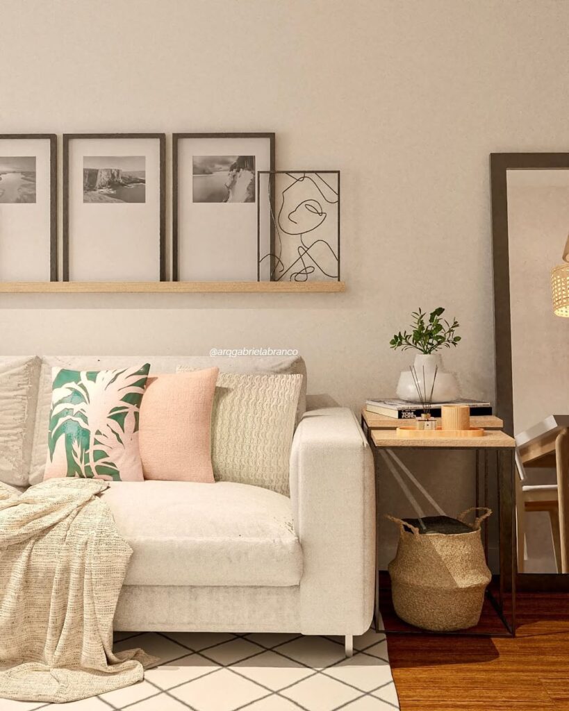 Sala de estar com sofá claro, almofadas coloridas e quadros minimalistas
