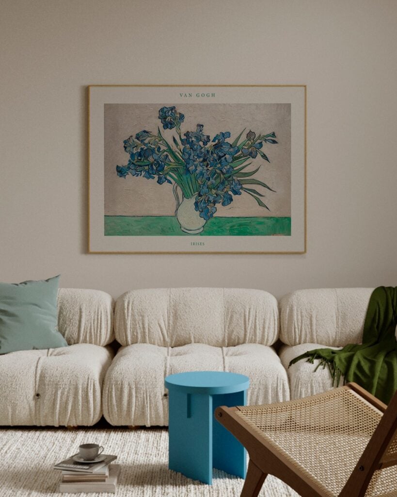 Sala com sofá orgânico bege, mesinha azul e quadro com flores azuis