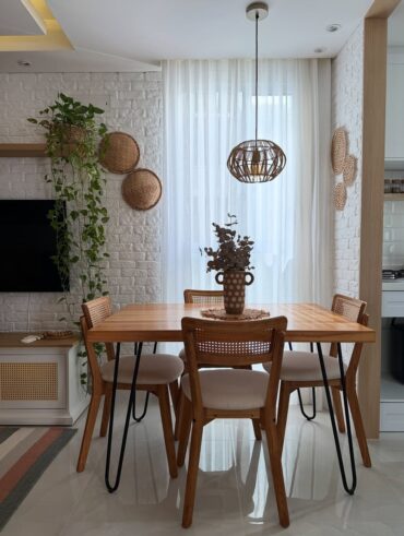 Sala de jantar com mesa e cadeiras de madeira e pendente de fibras naturais