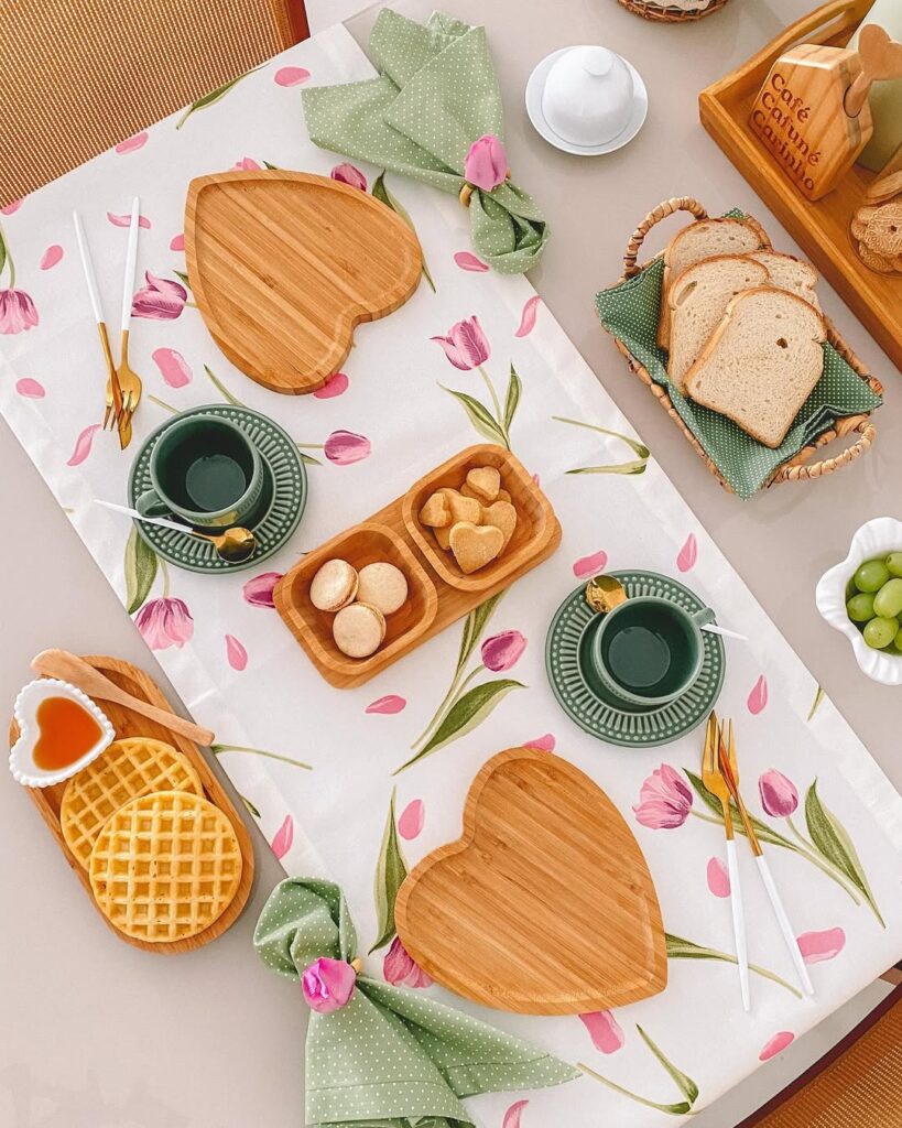 Mesa posta de primavera com caminho de mesa branca e tulipas rosa, bandejas de bambu em formato de coração