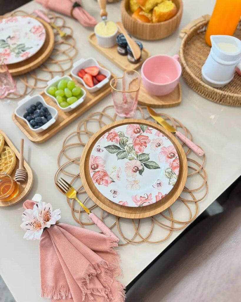 Mesa posta de primavera com pratos florais, guardanapos e xícaras rosa