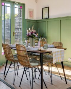 Ambiente com mesa, cadeiras, vaso com listras verde e brancas