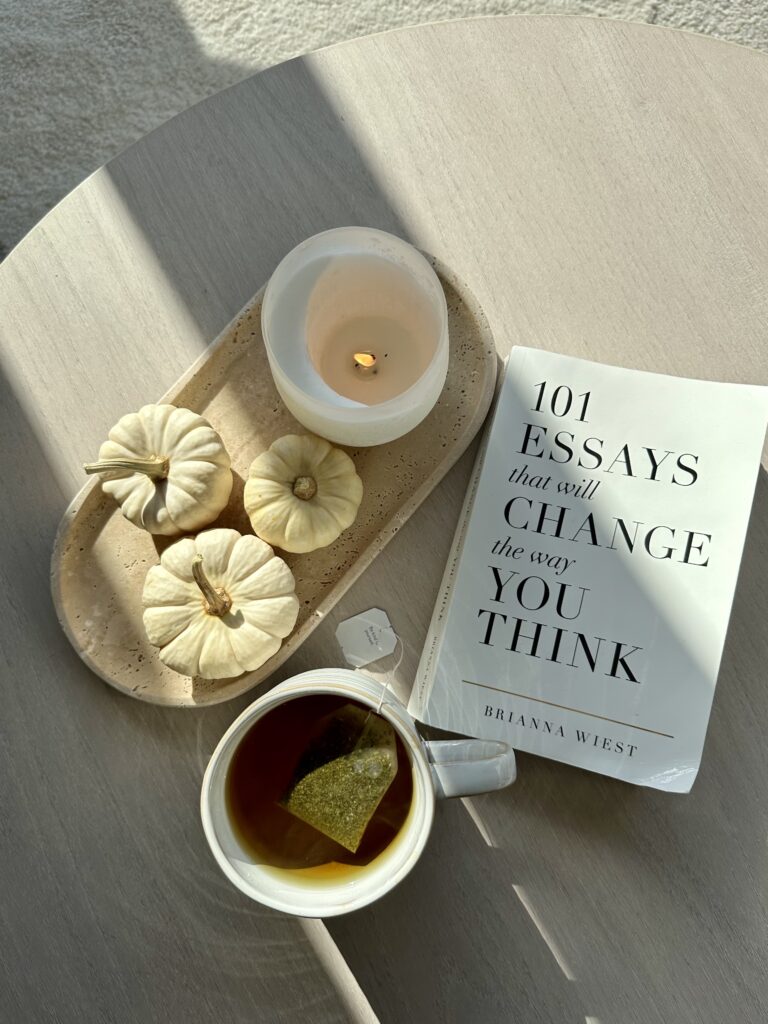 Livro, bandeja e uma xícara de chá sobre a mesa