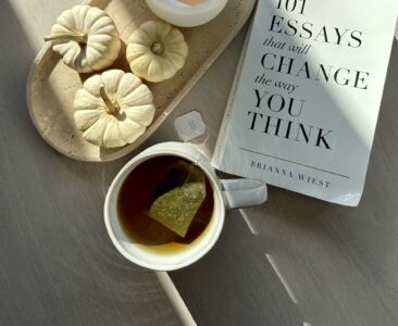 Livro, bandeja e uma xícara de chá sobre a mesa