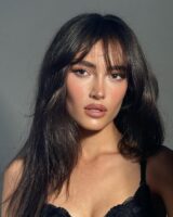Mulher de pele clara, com cabelo escuro e sobrancelhas marcadas