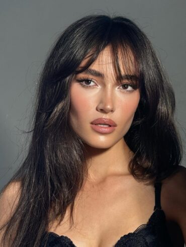 Mulher de pele clara, com cabelo escuro e sobrancelhas marcadas