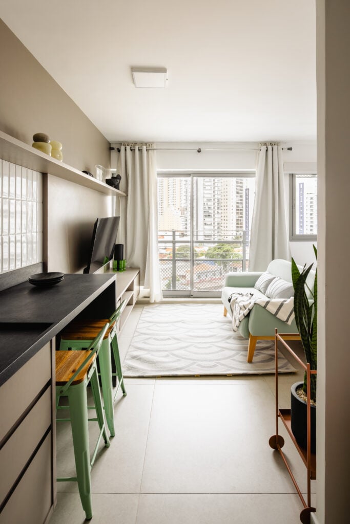 Sala com sofá verde-menta, ampla janela e tapete claro