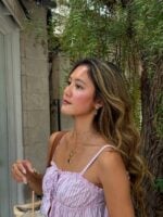 Mulher de pele clara, com cabelo loiro e regata listrada