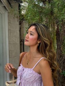 Mulher de pele clara, com cabelo loiro e regata listrada