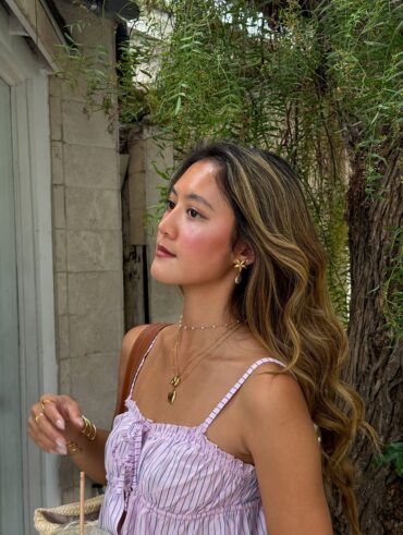 Mulher de pele clara, com cabelo loiro e regata listrada