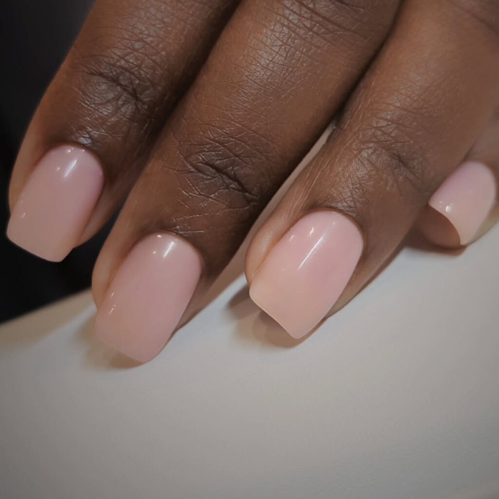 Mão de pele preta com unha quadrada e esmalte nude rosado 