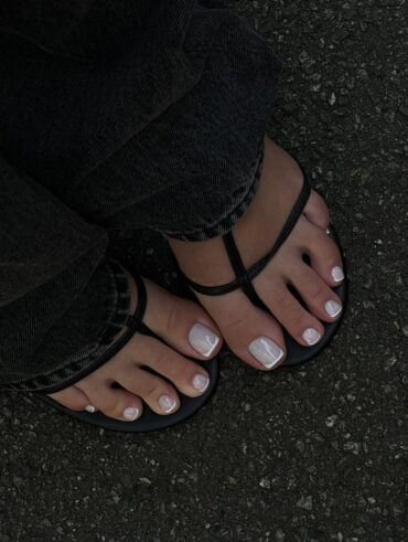 Pés de pele clara, com sapato aberto e unhas dos pés com francesinha