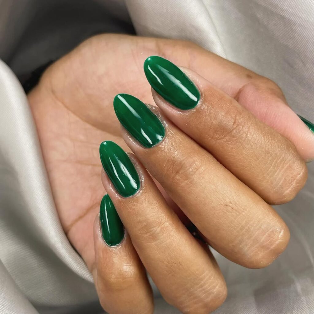 Mãos de pele preta-clara, com unhas amendoadas verde-esmeralda
