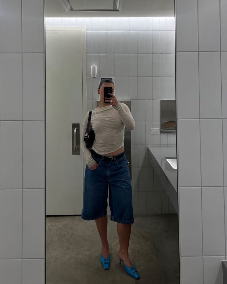 Mulher jovem usando blusa de manga longa, bermuda jeans e salto alto