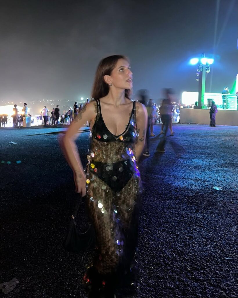 mulher jovem com top e hot pant preto e vestido transparente