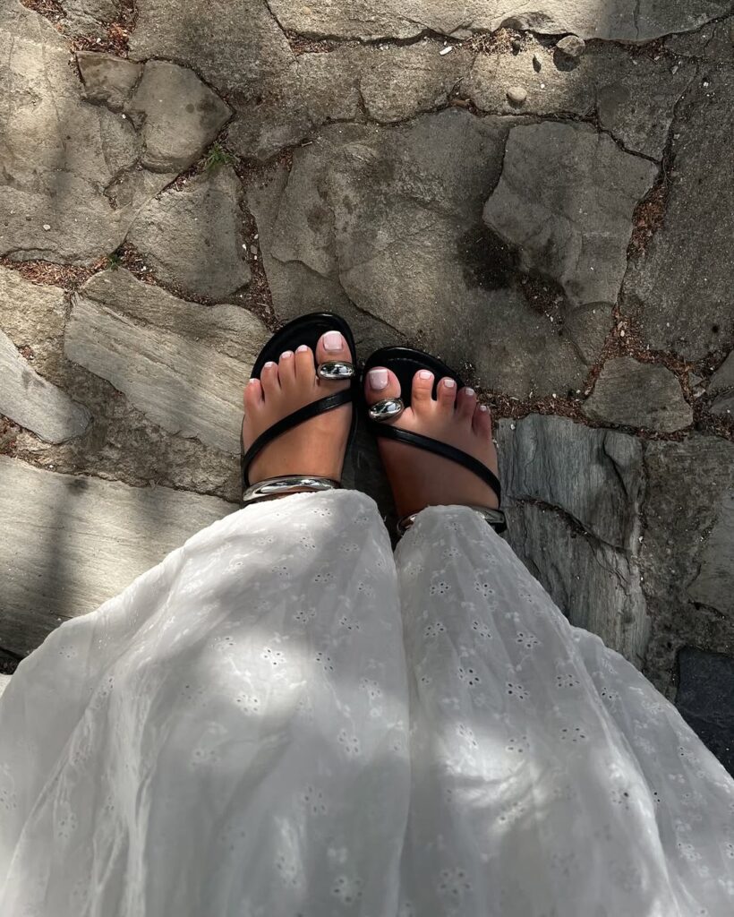 pés com unha pintada e sapatos com detalhe metálico nos dedos