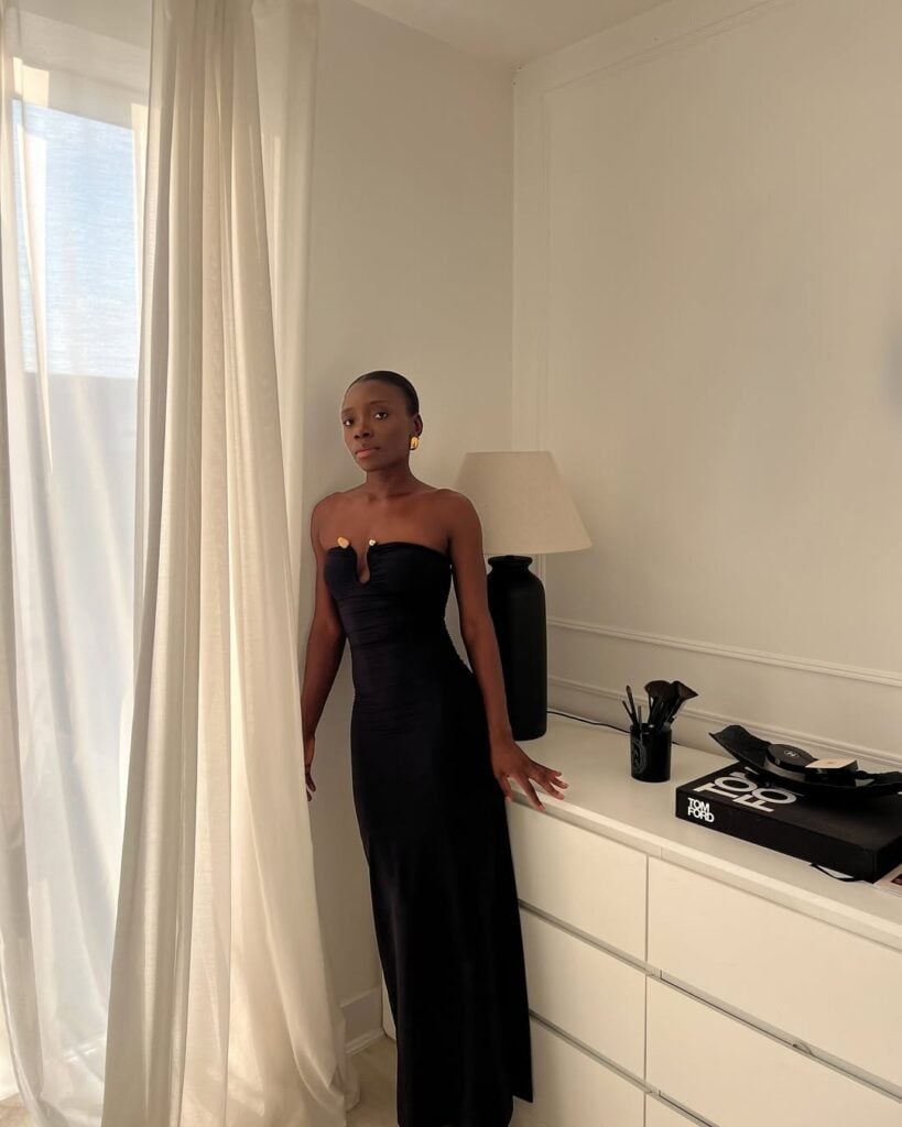 Mulher jovem e magra com pele negra e vestido sem alça