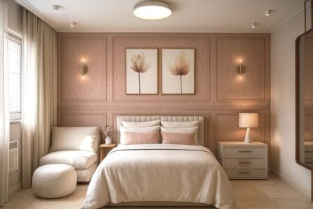 Quarto feminino em tons de rosa, com arandelas na parede e poltrona confortável