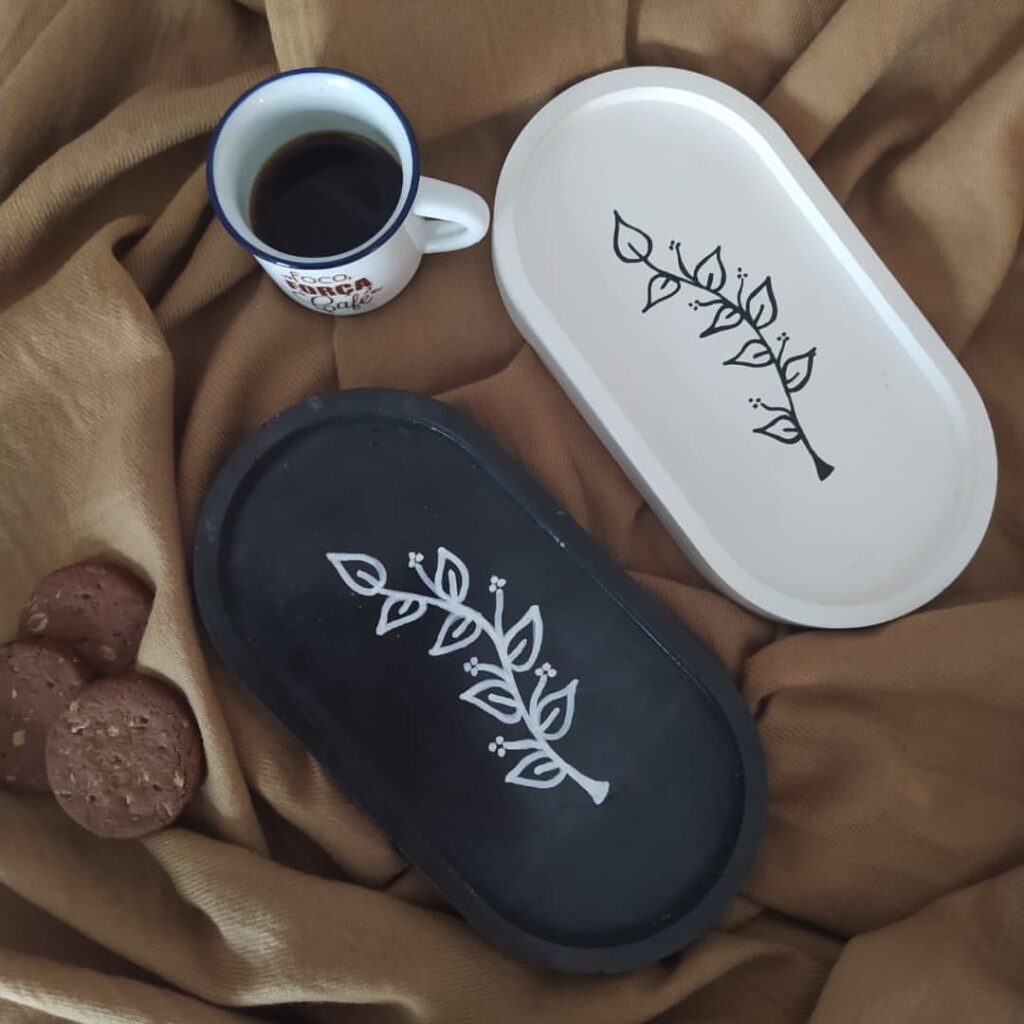 Bandejas decorativas de concreto em preto e branco com ramo de folhas