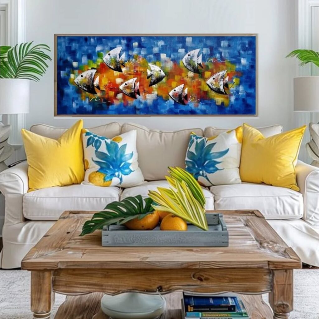 Sala de praia com sofá off-white, almofadas amarelas e quadro com peixes