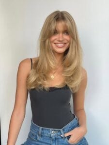 Mulher de pele clara, com cabelo loiro com franja