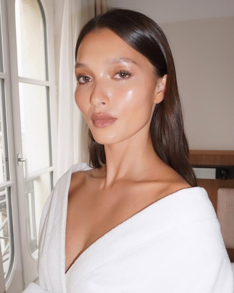 Mulher de pele clara, com cabelo escuro e glass skin makeup